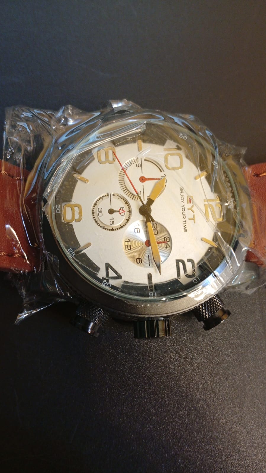 Reloj EYT, caja negra, esfera blanca, correa marrón.