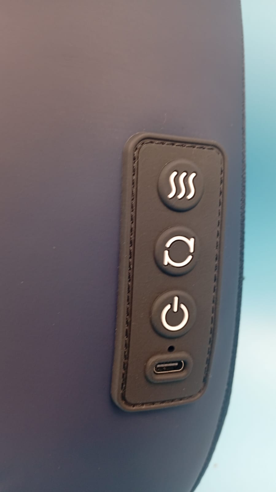 Masajeador de espalda de mano con mango ergonómico, superficie texturizada.